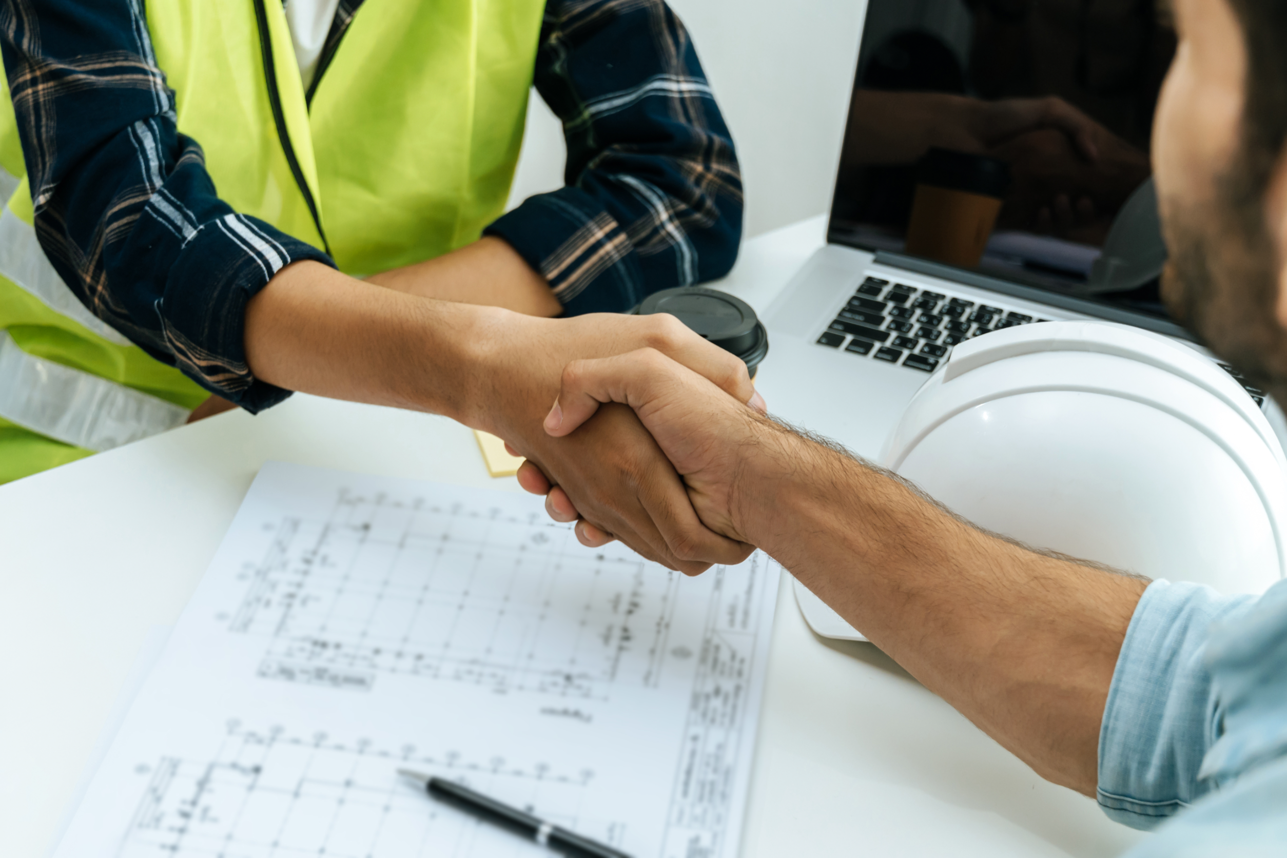 Office and Construction worker shake hands
